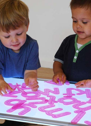 kinderen spelen met de silishapes alfabet letters op een lichtpaneel