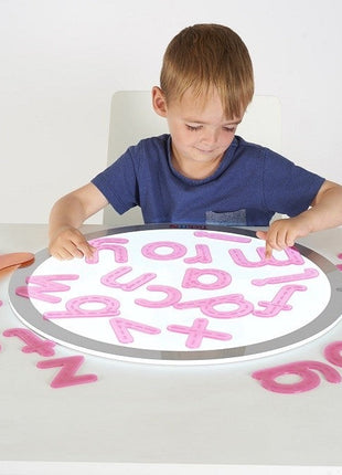 kind speelt met de silishapes alfabetletters op een lichtpaneel